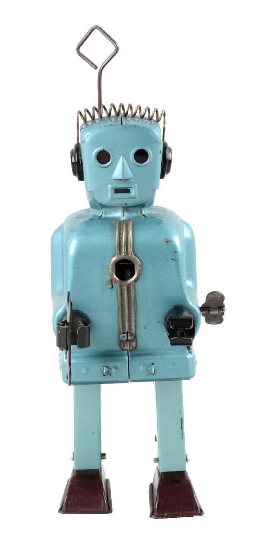 Japanese Tin Litho Wind Up Rachet Robot.: Made by Nomura. Marked "T. N. Japan" and "George G. Wagnor" (designer of the robot) on inside of the left leg. Robot works. When in operation it walks. Missing the plastic gel in the middle of the che