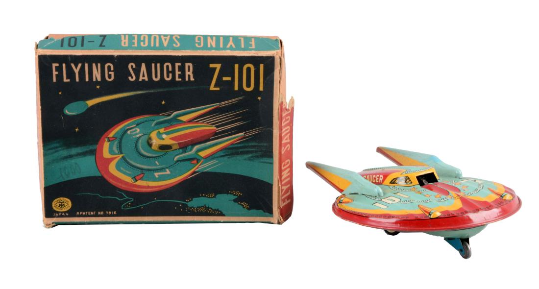 Japanese Tin Litho Friction Flying Saucer Z-101.: Includes original box with nice graphics. Made by Masudaya. Box has some splitting to side aprons and one small piece missing off of a side apron. Toy itself has nice color graphics. Some spots of fac
