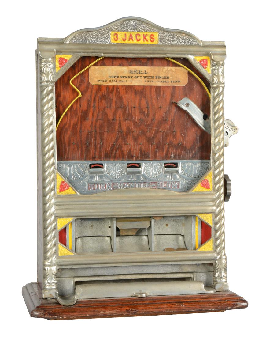 **1¢ Charles Fey & Sons 3 Jacks Counter Pocket Trade: For this countertop game players flip a coin into the playing field in the hopes of winning the contents of one of the three jackpot banks. Some wear is evident on the base and cabinet. A nice, unrest
