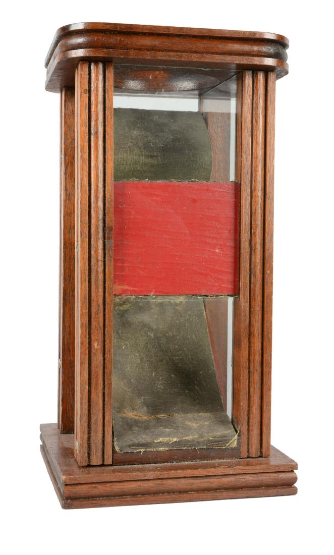 Dice Tower.: Dice are dropped into the top through the round opening and fly out of the bottom front of the drop. Dark green canvas lines the tiered channel for the dice. The outside of the tiers are painted red. 