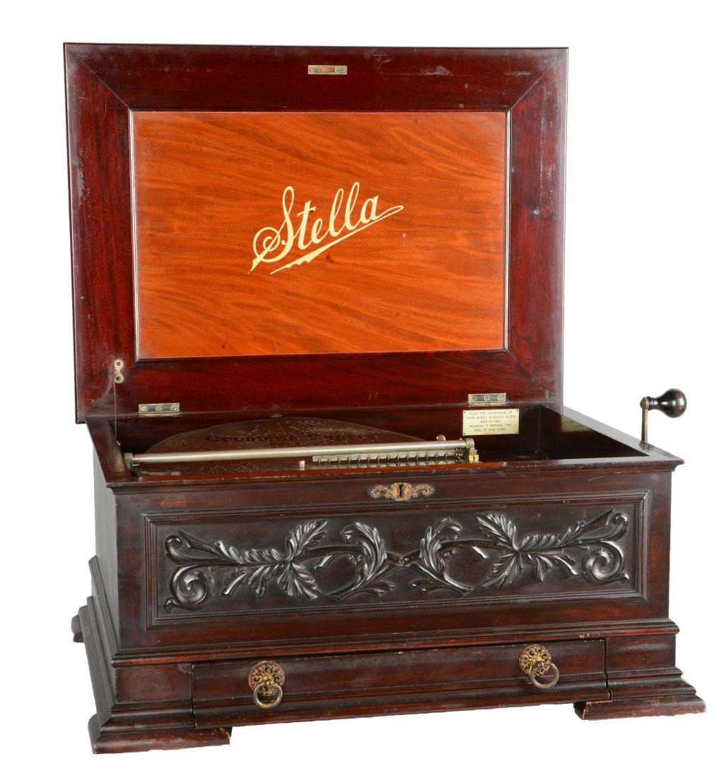 Stella Grand Disc Music Box With Discs.: This Swiss music box features a beautiful mahogany case with carved front design plays 17" music discs. The lower drawer contains 48 surplus discs. Serial No.2243. 29-1/2"W. x 20-1/2"D. x 13"T.