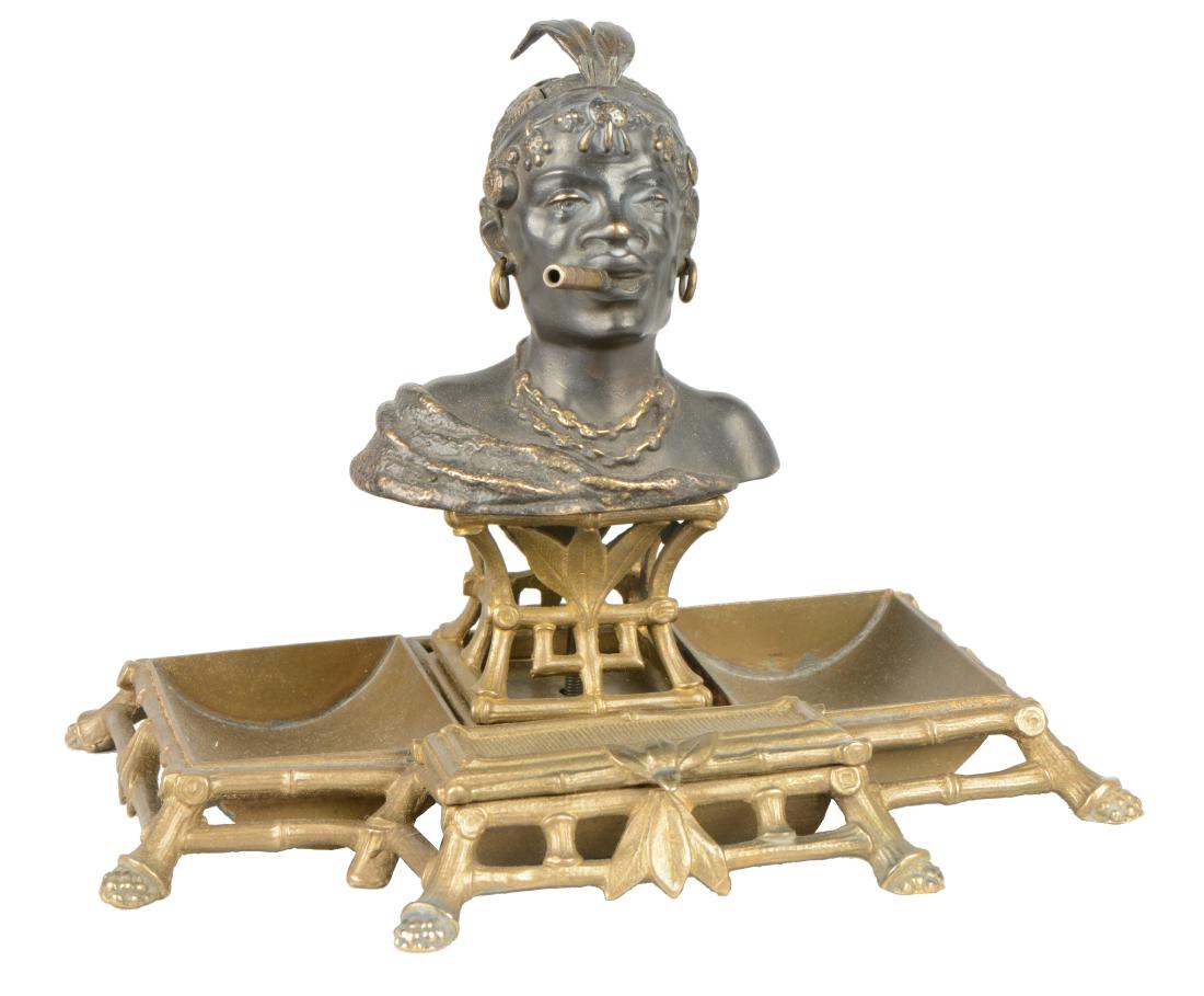 Figural Kerosene Lighter.: Figural Native man lighter with lower tray sculpted to look like bamboo. With hinged feathered headpiece on the man's head. 6"D x 8"W x 7"T.