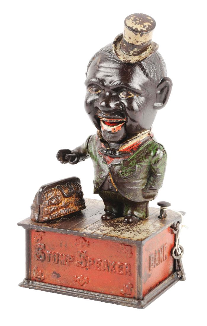 Shepard Hardware Stump Speaker Cast Iron Mechanical: Place a coin in the hand of the figure and press the lever. The coin is dropped into the satchel as the mouth goes up and down. Trap is not painted. Tiny hairline crack to rear of the platform. (JY).C