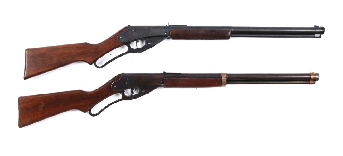 Lot Of 2: Daisy Red Rider Carbines.: (A) Stock has a crack where it connects to the metal. Screws have been boogered. Front and rear bands are copper. Front and rear sight are complete. Metal shows at 60%. (B) Wood is in good condition w