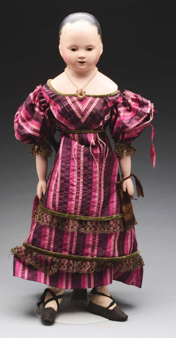 – Large French Papier Mache Shoulder Head Doll.: A French style doll with inset dark brown glass eyes, open mouth with upper and lower bamboo teeth and the molded & painted hair having wispy brush marks above each ear. The papier mache head is mount