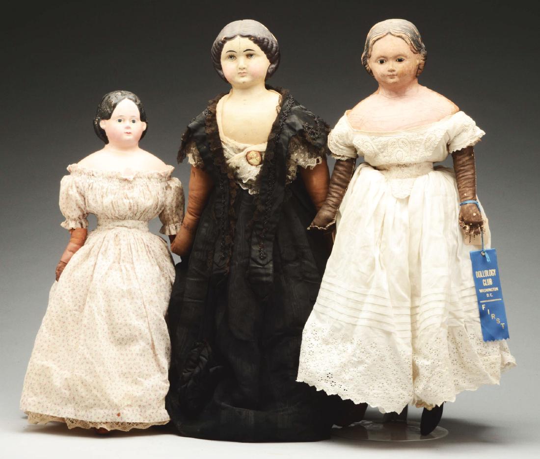 Lot of 3: Mid-19th Century Papier Mache Shoulder Head: The largest of the three is a 31” (80 centimeter) unmarked head with brown painted hair, molded and painted features, on a cloth body with patterned material on the legs to represent stockings and l