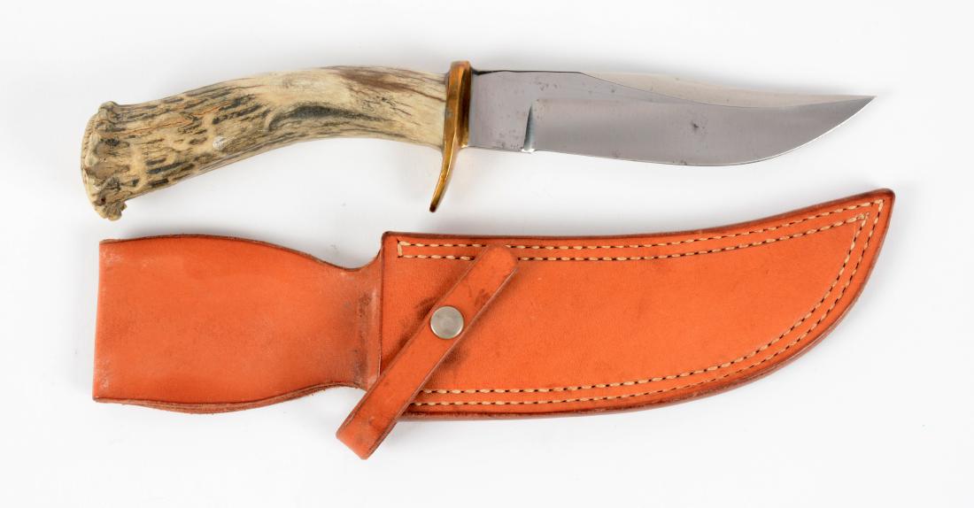J.N. Cooper Stag Handled Hunter.: Saber ground clip point with sharpened false edge. Handled in crown stag with heavy brass half guard. Correct sheath signed "Cooper". Circa Cooper in Double Eagle.Blade Length: 5-1/8"Overall Length: 1