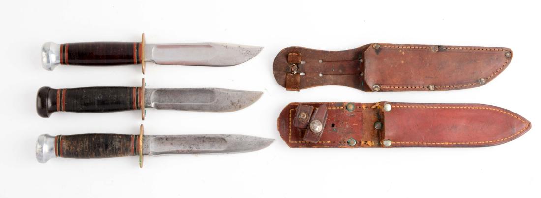 Lot of 3: Marbles Gladstone Mich. USA "Ideal" Fixed: Knife A) Clip point with fullers. Stacked leather handle with aluminum crown and full brass guard. Circa post-1943. Non-original leather sheath. In fair condition. Knife B) Clip point with fullers. St
