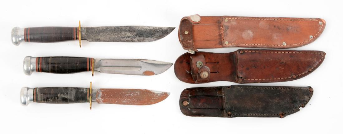 Lot of 3: Marbles Gladstone Mich. USA "Ideal" Sheath: Knife A) Clip point with fullers. Stacked leather handle with aluminum crown and brass half guard. Incorrect leather sheath. Circa pre-1943. Condition of knife: In very good to excellent condition. Kn