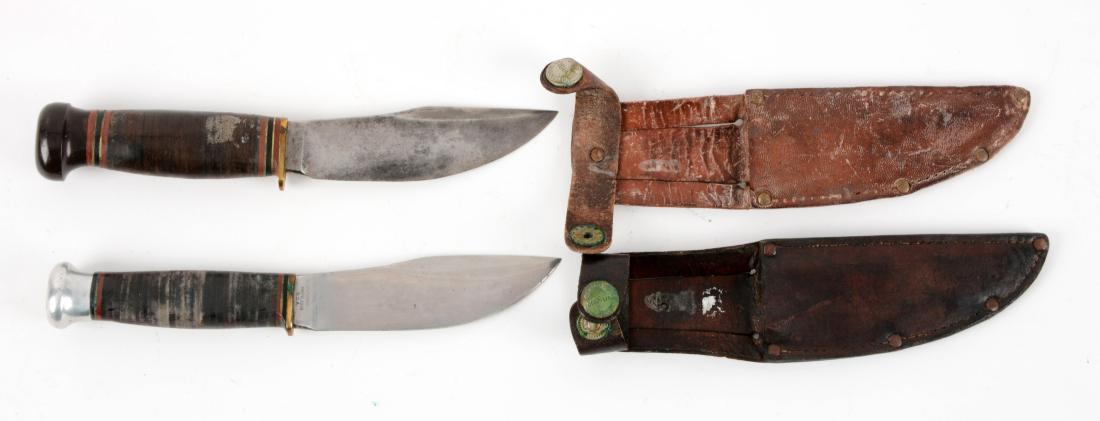 Lot of 2: Marbles Gladstone Mich. USA "Woodcraft": Knife A) Flat ground Skinner with thumb grooved back. Handled in stacked leatehr with aluminum crown and brass half guard. Correct leather sheath with signed safety snap. Circa pre 1943. In good to ve