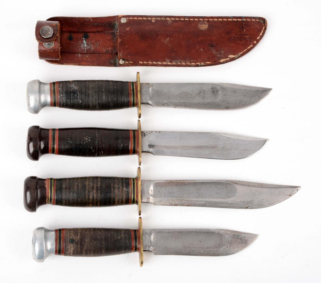 Lot of 4: Marbles Gladstone Mich. USA "Ideal" Fixed: Knife A) Clip point blade with fullers. Handled in stacked leather with aluminum crown with full brass guard. No sheath. Circa post 1943. Knife B) Clip point blade with fullers. Handled in stacked lea