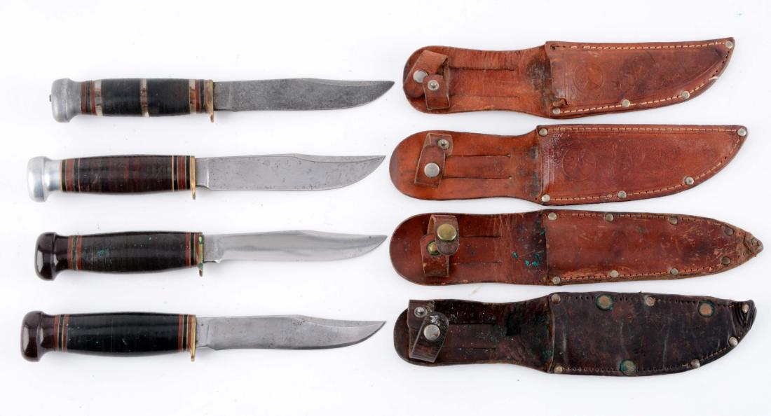 Lot of 4: Marbles Gladstone Mich. USA "Expert" Fixed: Knife A) Flat ground clip point blade. Handled in stacked leather with Bakelite crown and brass half guard. Circa pre 1943. Incorrect sheath. Knife B) Flat ground clip point blade. Handled in stacked 
