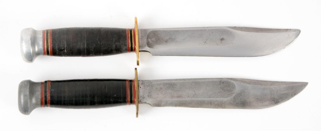 Lot of 2: Marbles Gladstone Mich. USA "Ideal" Sheath: Knife A) Clip point with fullers. Stacked leather handle with aluminum crown and full brass guard. No sheath. In good to very good condition. Knife B) Clip point with fullers. Stacked leather handle w