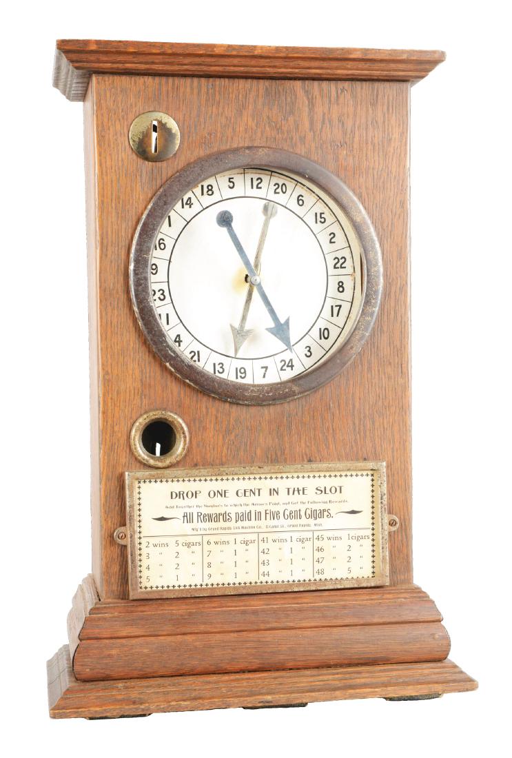 **1¢ Grand Rapids Slot Machine Co. Trade Stimulator.: Housed in a wood cabinet, this countertop pointer game features twin arrows and offers up to five cigars for numbers adding up to a particular total. Missing the back door and showing some wear to the