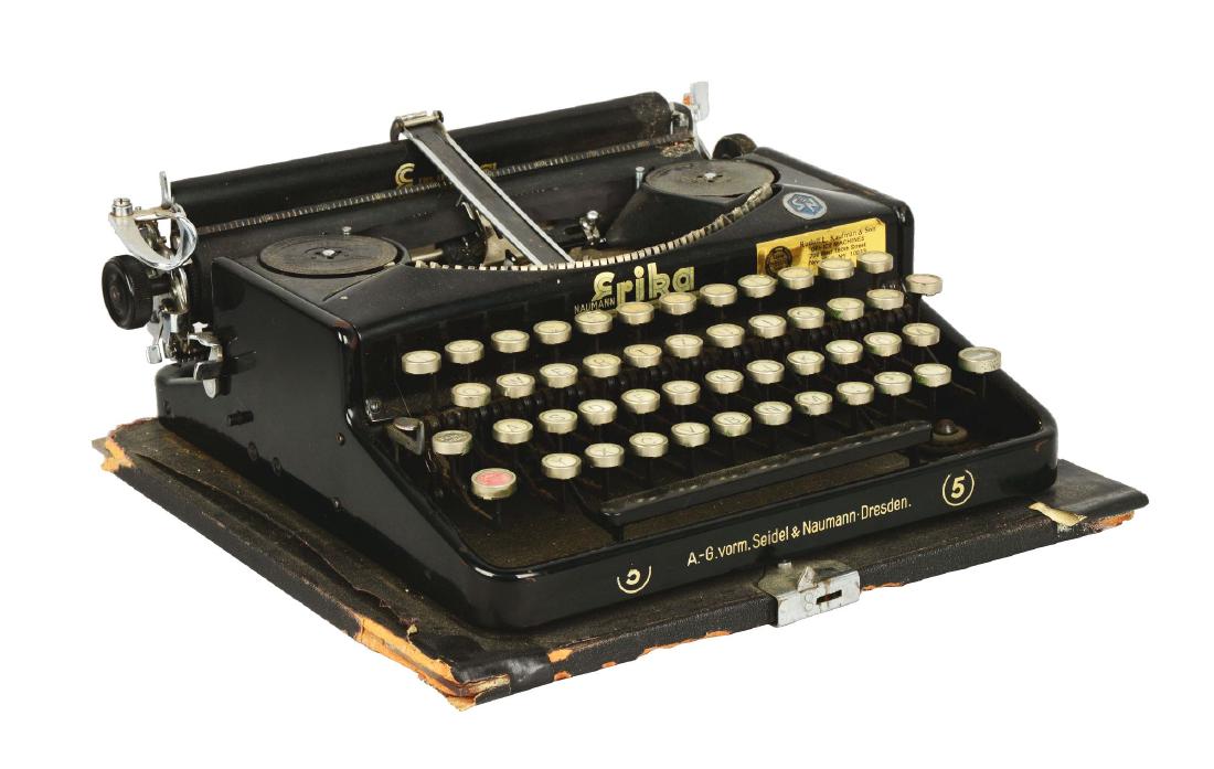 Seidal & Nauman Erika No. 5 Typewriter.: Black metal typewriter with white keys and minor gold details. Showing the traditional QWERTY keyboard with a few keys rearranged, some written in German. Fully operational; types well. Carriage must 