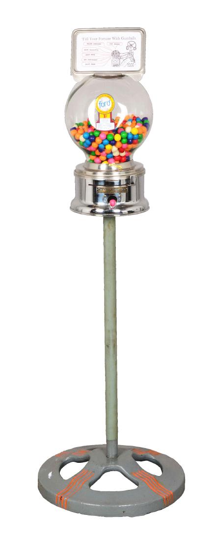 1¢ Ford Gum Machine Co. Ball Gum Vending Machine On: Gum ball vendor with chromed base and clear glass globe, made of iron. The upper marquee touts "Tell Your Fortune With Gumballs" and shows an illustration of a swami and the fortune selections. Circa