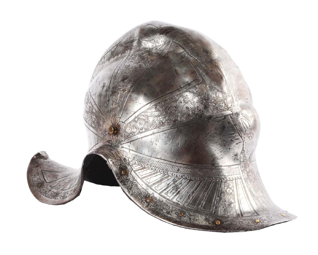 Extraordinary One-Piece Italian Parade Burgonet from: Circa 1650. Heavy skull forged in one piece together with the brims. Etched in the classic Pisan manner with trophies of arms, floral panels. The comb being a beautiful, highly embossed and engraved d