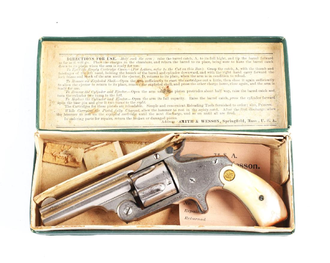 (A) Boxed S&W Model 2 2nd Issue Spur Trigger Single: Manufactured 1877 to 1891. Features five shot, single action, spur trigger, tip-up, factory nickel and case colored hammer. Two line address on barrel rib. Sport as pair of Smith & Wesson gold medalli