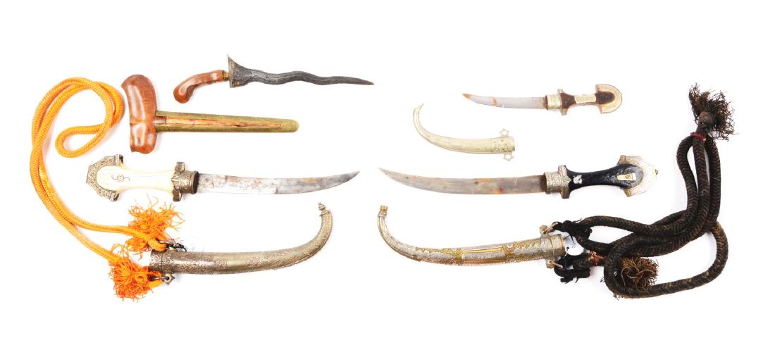 Lot of 4: Indonesian & African Daggers.: Comprising: (A) A North African Koummya with steel double edged curved blade. Wood and engraved German silver hilt. Engraved German silver scabbard. Very good condition; a few scattered marks. (B) A d