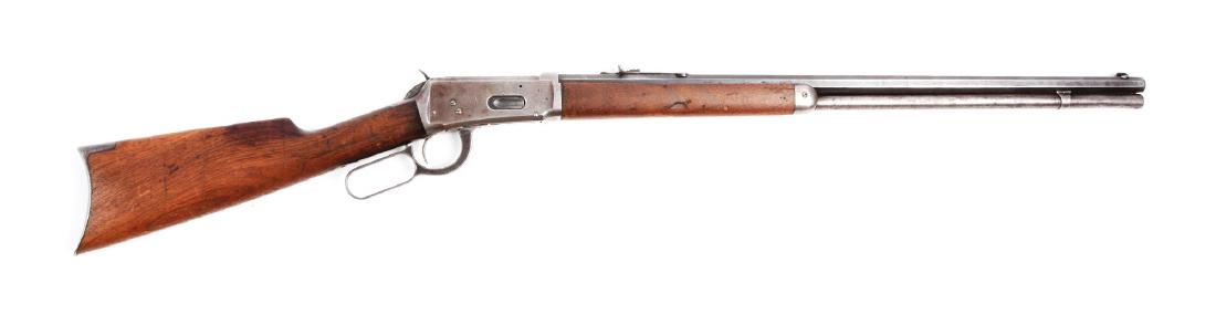 (C^) Winchester Model 1894 Lever Action Rifle.: Rifle was manufactured in 1905. Standard features: octagon barrel, full magazine, sporting sights, blue finish, and walnut stocks with rifle buttplate. Metal is all gray patina with flashes of blue on