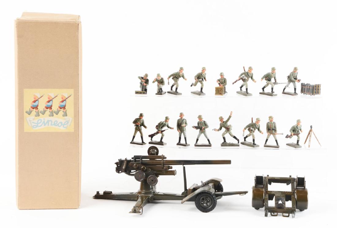 German Lineol Field Gun & Composition Soldiers With: From the Collection of Investment Rarities Inc. Brush and netting inside box, large field gun and trailer accompanied by 16 various Lineol soldiers. Dimensions: Box : 16" x 5 -1/4". Condition: (Excell
