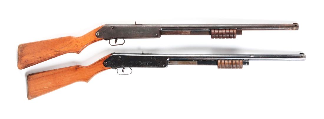 Lot of 2: Daisy Model 107 Buck Jones Special Air: Both have slide action, blue finish, sundial markings on wooden stock, needle or floating compass, Daisy marked on compass dial, 60 shot gravity fed magazine and six groove slide handle. Manufactured