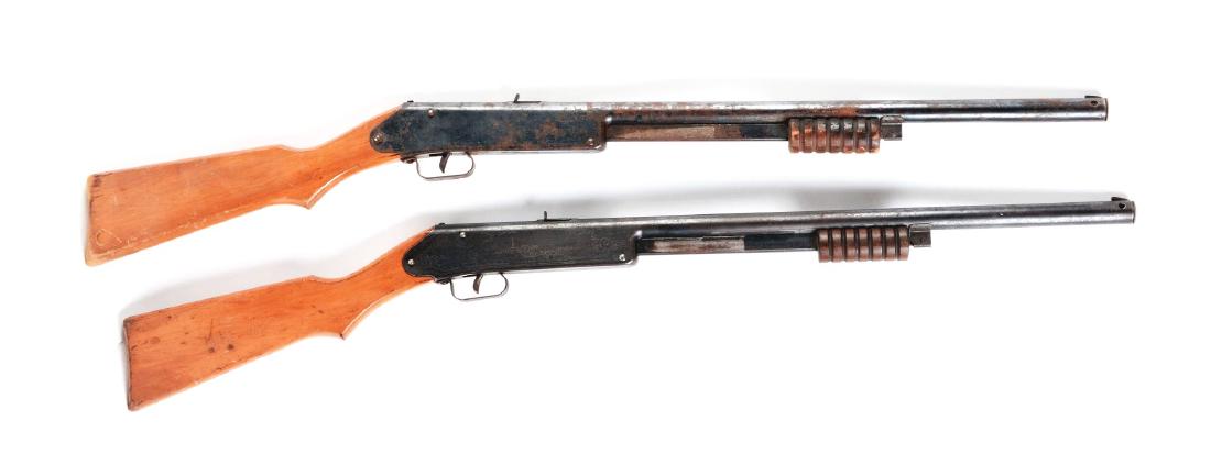 Lot of 2: Daisy Model 107 Buck Jones Special Air: Both have slide action, blue finish, sundial markings on wooden stock, needle or floating compass, Daisy marked on compass dial, 60 shot gravity fed magazine, six groove slide handle. Manufactured 193