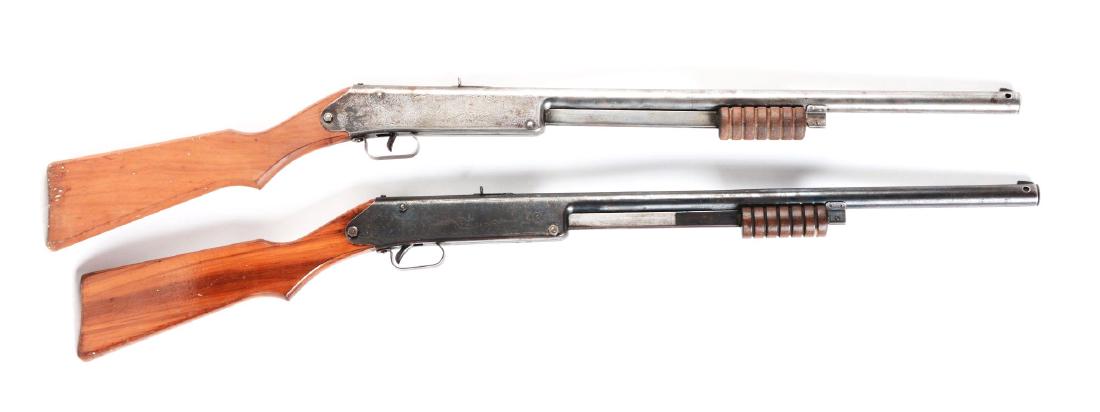 Lot of 2: Daisy Model 107 Buck Jones Special Air: Both have slide action, blue finish, sundial markings on wooden stock, needle or floating compass, Daisy marked on compass dial, 60 shot gravity-fed magazine, six groove slide handle. Manufactured 193
