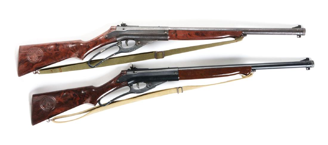 Lot of 2: Daisy No. 142 Defender Model Air Rifles.: Both are BB/.175 caliber, 1000 shot, gravity fed, military-style two-piece plastic stock with extended forearm, blue or painted finish, lever-action, web sling. Plastic stocks has stamp on both sides.