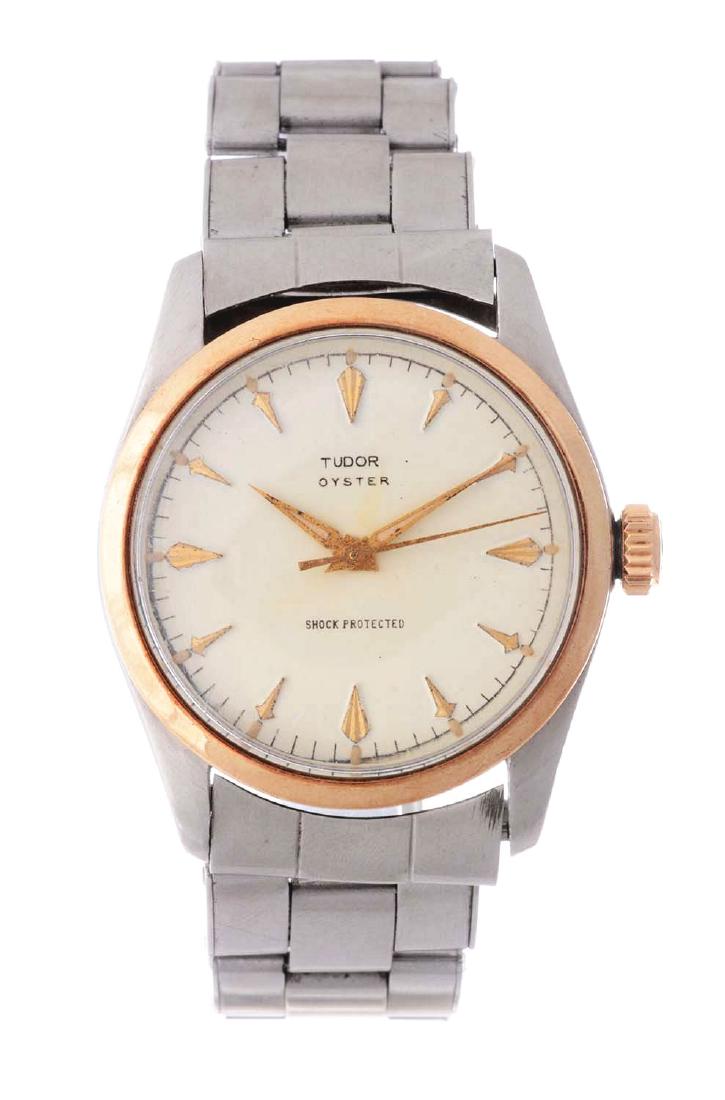 Vintage Tudor Stainless Steel 14k Yellow Gold Oyster: Vintage Tudor Stainless Steel 14k Yellow Gold Oyster. The model number of this Tudor is 7904. The case is stainless steel featuring a 14k yellow gold bezel and refinished white dial with yellow gold a