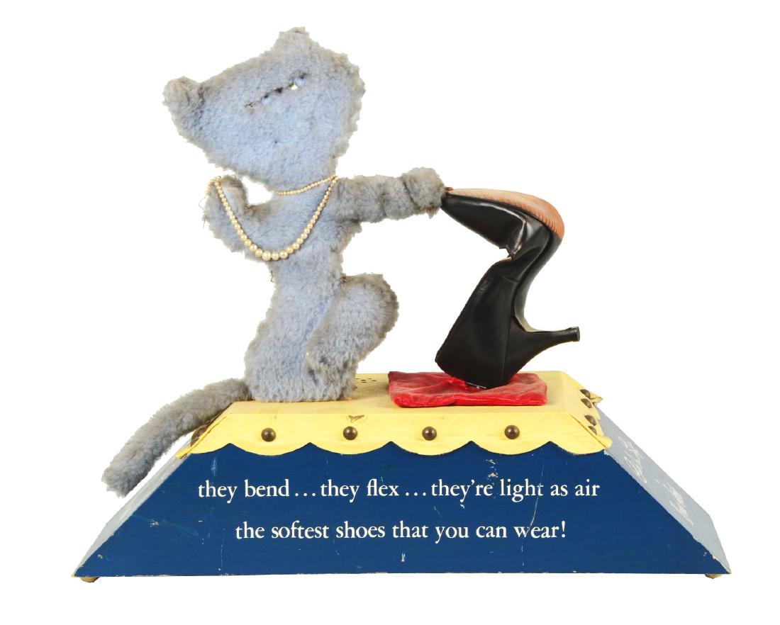 Enna Jetticks Shoe Display.: This store display shows a plush blue cat wearing pearls and bending a high heeled shoe, mounted to a blue and yellow base. Wear and soiling is present throughout. . Condition: (Good). Dimensions: 21"