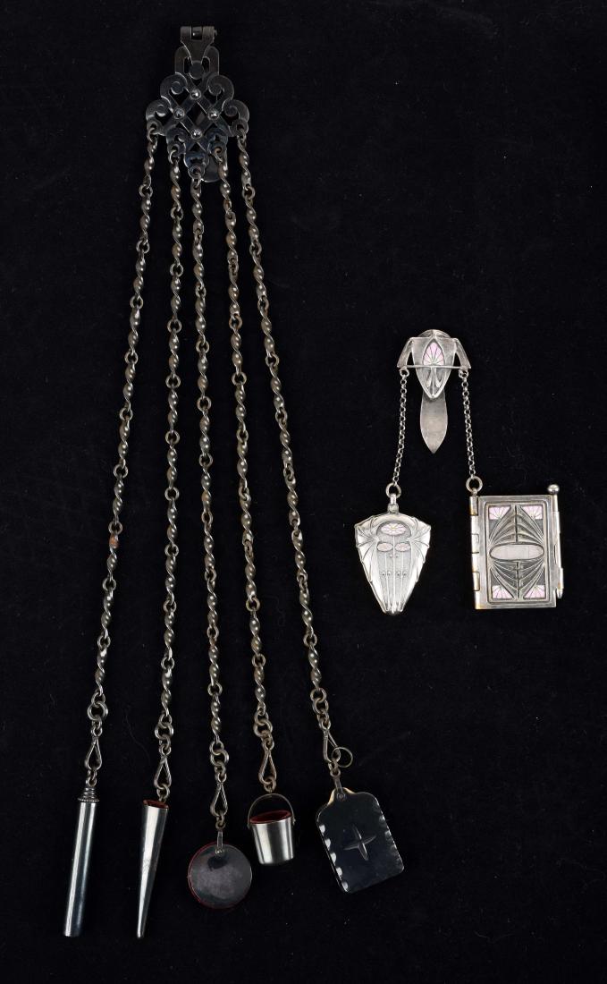 Lot of 2: Antique English Victorian Chatelaines.: The first is a silver plated and enamel, Art Noveau with a mirror and booklet with pencil. The second is a black lacquered Chatelaine with five accessories; tablet, thimble holder; pin cushion; scisso