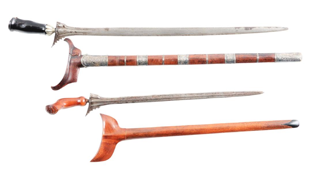 Lot of 2: Executioner's Kris.: Comprising: A) Straight Damascus steel blade with scalloped guard, carved ebony handle with silver ferrule and complete with wooden scabbard with repousse silver mounts. Fair condition, blade has a fr