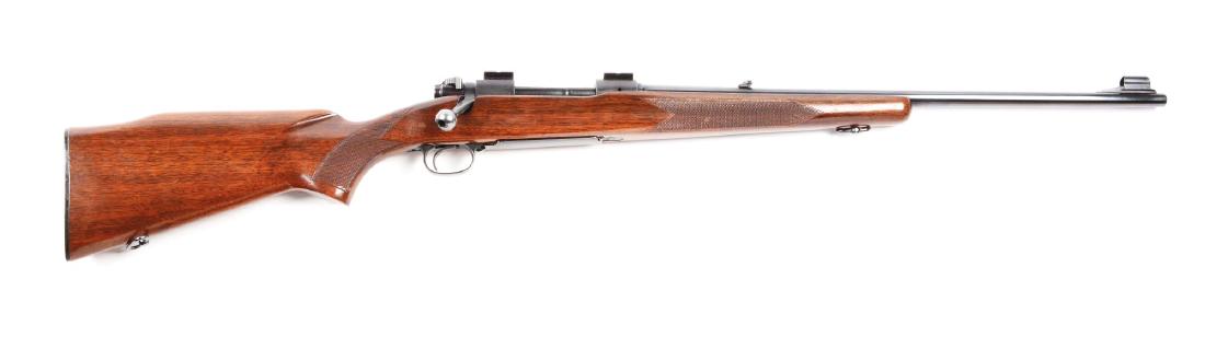 (C) Pre-64 Winchester Model 70 Featherweight Bolt: Manufactured 1959. Matching bolt. Features full round barrel, hooded ramp front sight, folding leaf rear sight, blued finish, scope bases mounted, pistol grip checkered walnut stock with fluted Monte