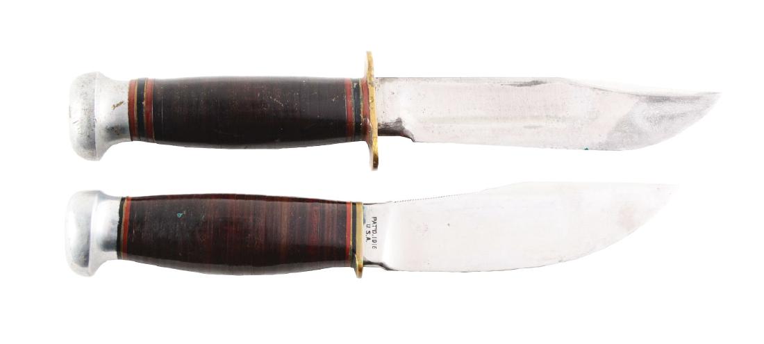 Lot of 2: Marbles Gladstone Fixed Blade Knives.: (A) "Ideal" with 5" blade; 9 - 1/4" overall. Handled in stacked leather with brass full guard and aluminum crown. No sheath. Circa post-1942. (B) "Woodcraft" with 4 - 1/2" blade; 8 - 3/8" overall. Han