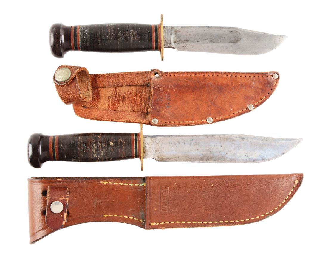 Lot of 2: Marbles Gladstone Fixed Blade Knives.: (A) Marbles - Gladstone Mich. U.S.A. - "Ideal" 4 - 3/4" fixed blade; overall 9". Handled in stacked leather with brass full guard and lignum vitae crown. Comes with leather sheath signed "MARBLES" on