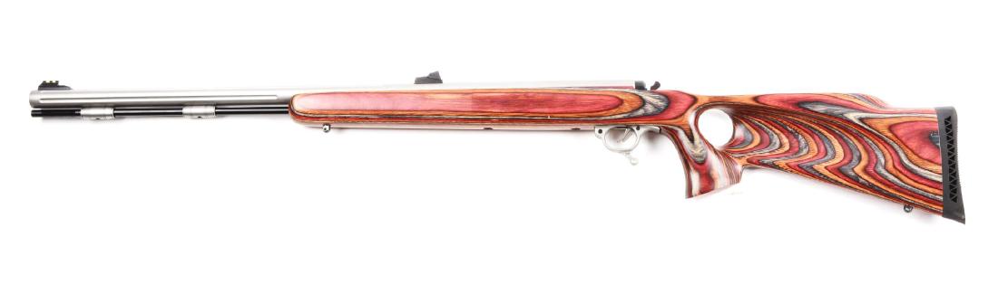 (A) Left-Handed Thompson Center Omega Model .50 Caliber: Features a matte stainless partially fluted barrel with adjustable fiber optic sights Triggerguard lever opens breech to insert cap. Multi-colored laminated wood thumbhole stock for left handed shoote