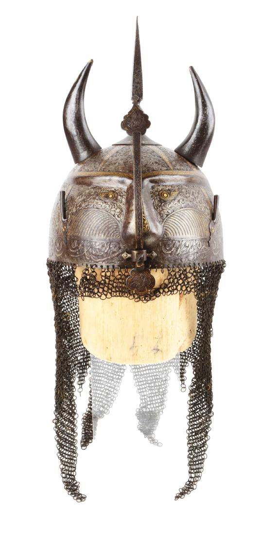 Persian Qajar Devil Form Helmet with Gilt Decoration.: Steel construction, the skull features a molded three dimensional devil accented with silver and gold kaftgari and decorated with chiseled floral scrolls and and Eastern motifs throughout, base of bro