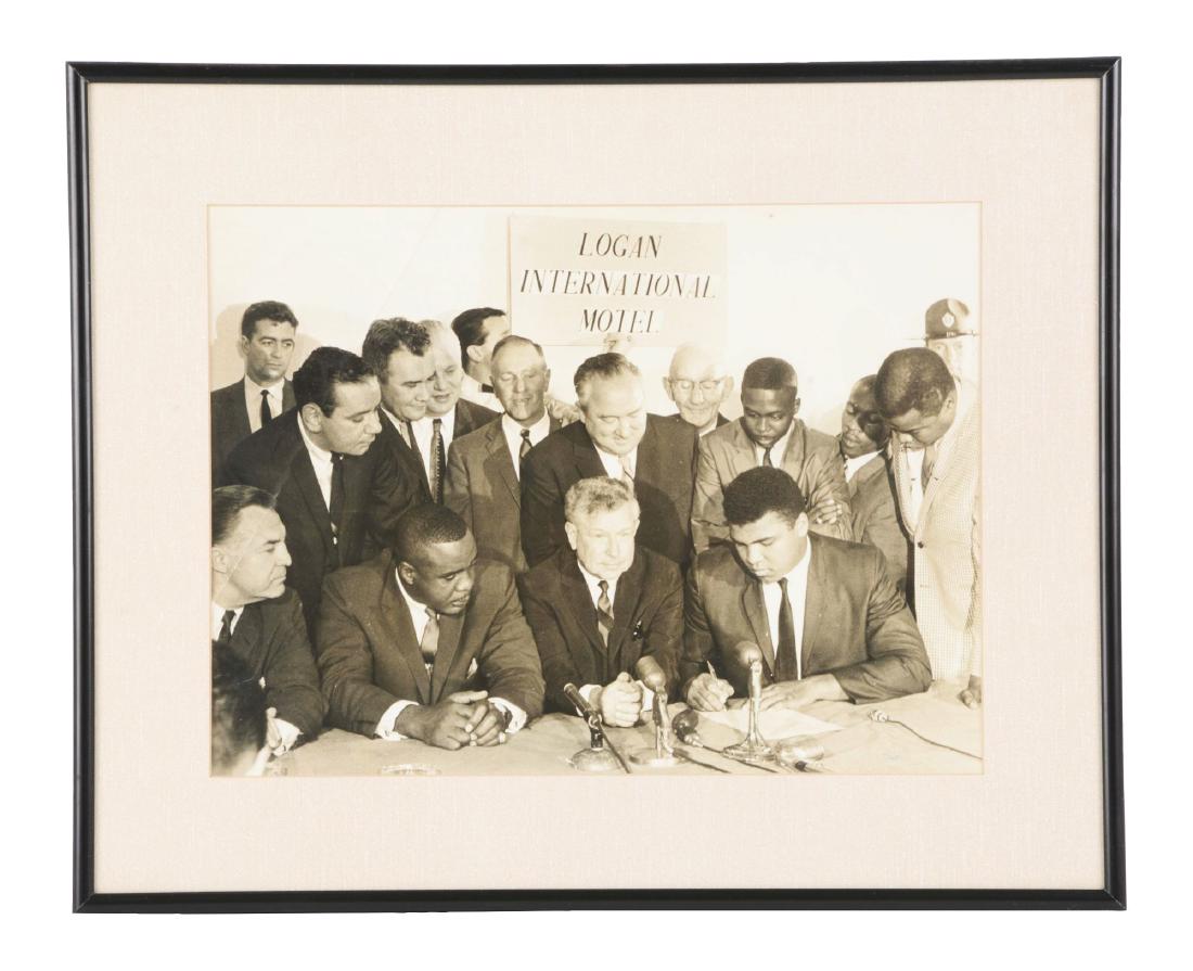 Oversized Cassius Clay and Sonny Liston Contract: Large format photograph of Cassius Clay and Sonny Liston signing the contract for their bout in Boston that eventually took place in Lewiston, Maine. The photo has a crease on the left side and is VG 