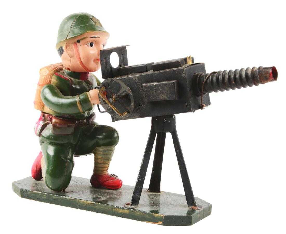 Pre-War Japanese Wind Up Machine Gunner.: Very early version, pre-war kneeling soldier marked "Japan" on bottom and on wooden base with early tin windup machine gun. Small dent in top of helmet, otherwise the celluloid is nice. The left arm n