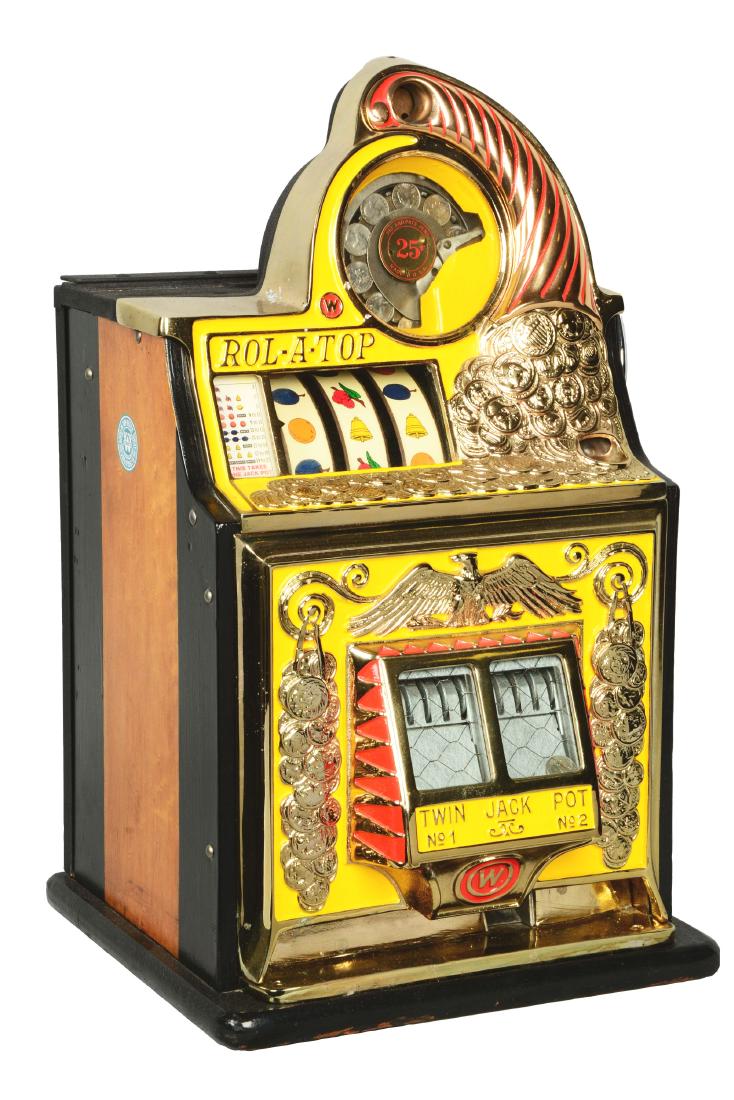 **Reproduction 25¢ Watling Rol-A-Top Coin Front Slot: This three-reel slot machine is yellow in color and features an upturned cornucopia spilling golden coins over the top and front of the machine. With twin jackpot banks proudly displayed front and cen
