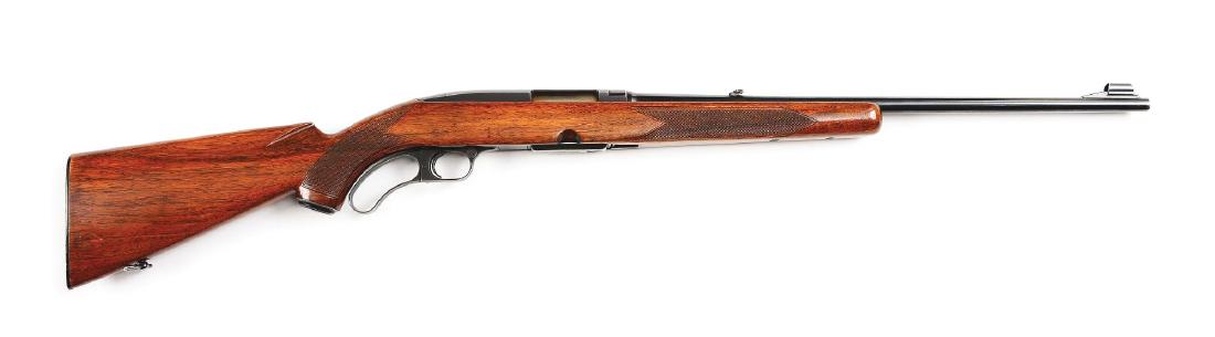 (C) Winchester Model 88 Lever Action Rifle (1957).: Features hooded front sight, folding leaf rear sight, lever activated bolt design, five round detachable box magazine, one piece checkered walnut stock with factory sling swivel, and black plastic Win