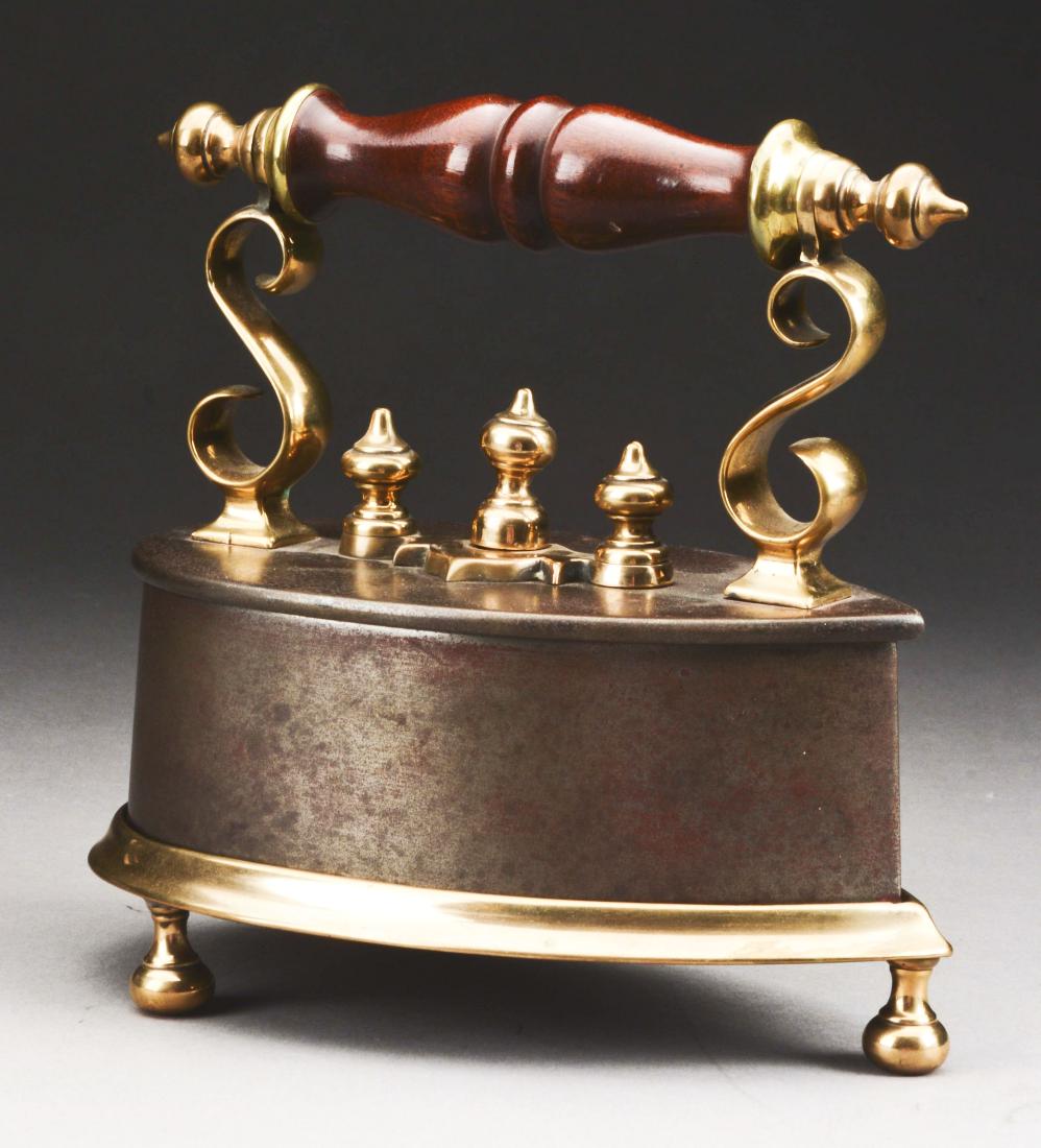 Scottish Iron And Brass Flat Iron On Original Stand.: Mid 19th century, Scotland. This fine example of typical form. The removable top section, latching with scrolled brass lever, opening to reveal a compartment designed to house a cast iron slug of conf