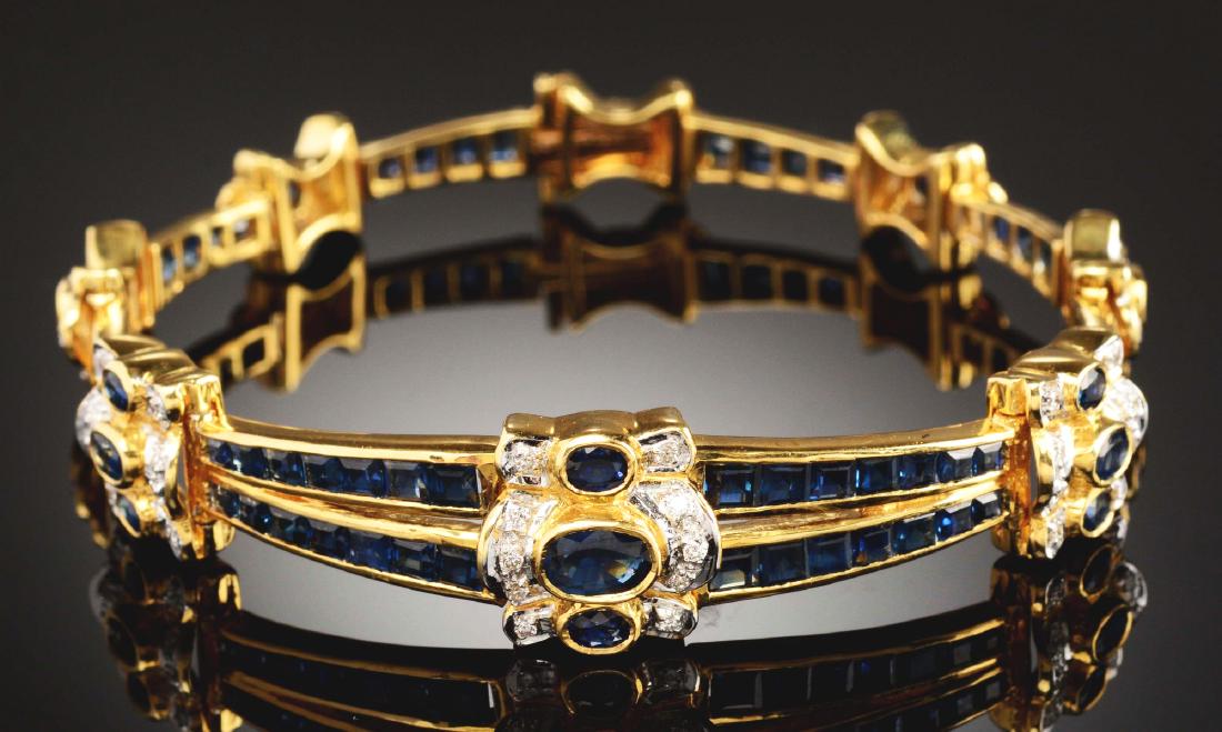 18k Gold, Sapphire & Diamond Tennis Bracelet.: 18k yellow gold sapphire and diamond tennis bracelet consisting of fourteen bezel-set faceted oval blue sapphires, fifty-two channel-set faceted square cut blue sapphires, and fifty-six round full cut