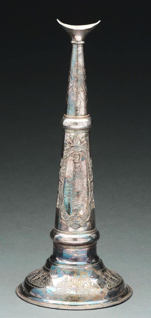 Silver Plated Fireman's Horn.: Silver plated fireman's horn made by Fred Miller and presented to Captain G.E. Lockwood. The presentation is framed by an applied device of a hydrant, wrist lantern, helmet, trumpet, ax, hose and ladd