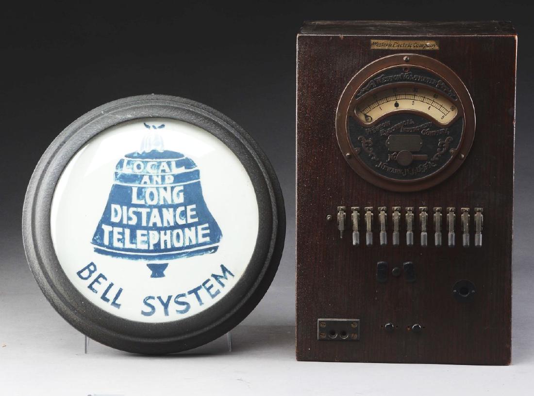 Western Electrical Volt Meter with Bell System: Early to mid 20th century, American. The Voltmeter with engraved cast brass name plate encasing the voltage dial above a row of controls encased in an oak cabinet. The round Bell System wall sign with