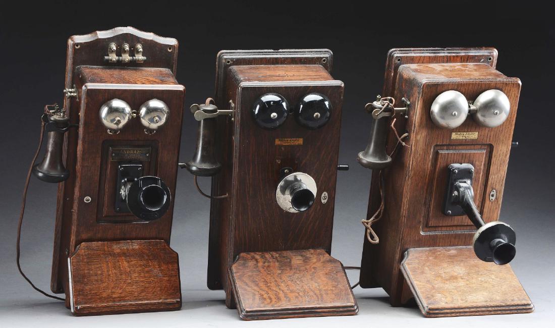 Lot Of 3: Oak Wall Phones.: Early 20th century. The first is a rare Julius Andre & Sons example, all original. The other two are by the Western Electric Company, one with a replaced mouth piece. Condition: Dimensions: Largest : 