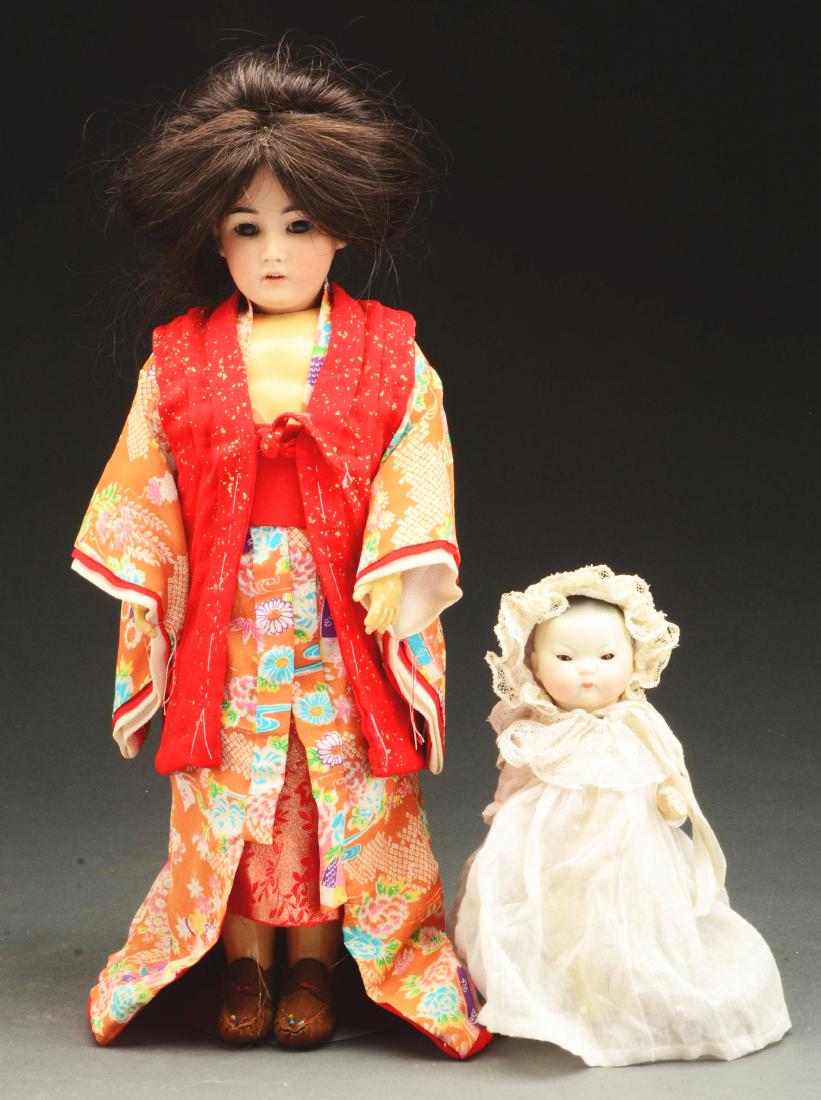 Lot of 2: Bisque Head Dolls Representing Asian: The larger is a 17-1/2" girl with amber tinted bisque incised on back of head "1329 Germany Simon & Halbig S&H". She has brown glass sleep eyes, well-painted lashes and brows and an open mouth with fo