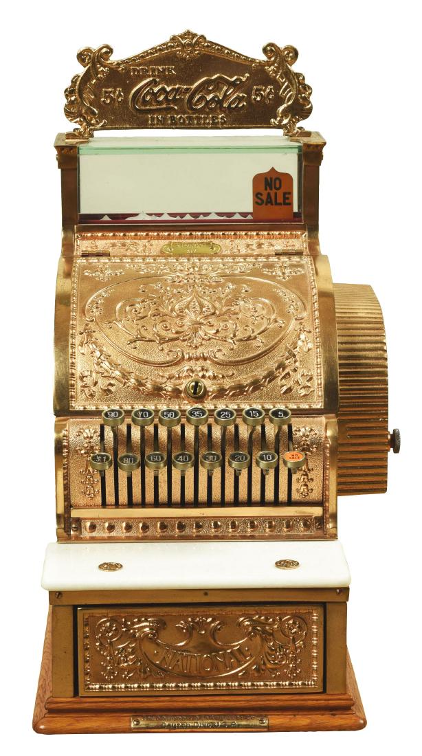 National Cash Register Model 317 With Coca Cola: A Model 317, yellow brass with dolphin pattern, 15 key, direct key operated total adder, and an oak base. There is a brass "Drink Coca-Cola In Bottles 5¢" marquee on top. Serial No. S166000N. Conditi