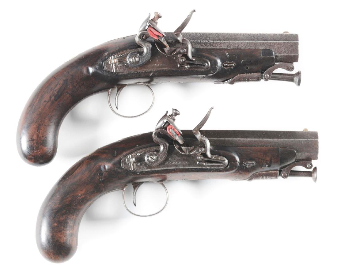 (A) Cased Pair of English Flintlock Officer's Pistols: Circa 1800. Cased in a contemporary box with some accessories. Pistols have signed and engraved bolted locks with push on safeties. Goose neck cocks and roller bearing frizzes. The octagonal barrels h